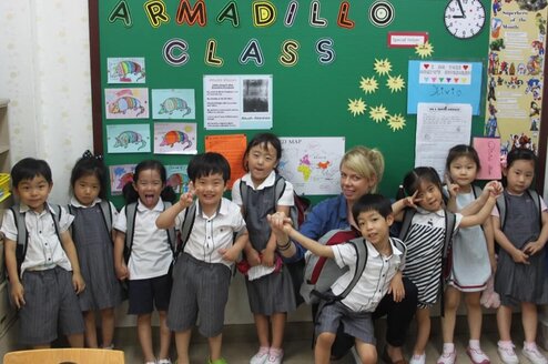group of children in uniforms in front of board